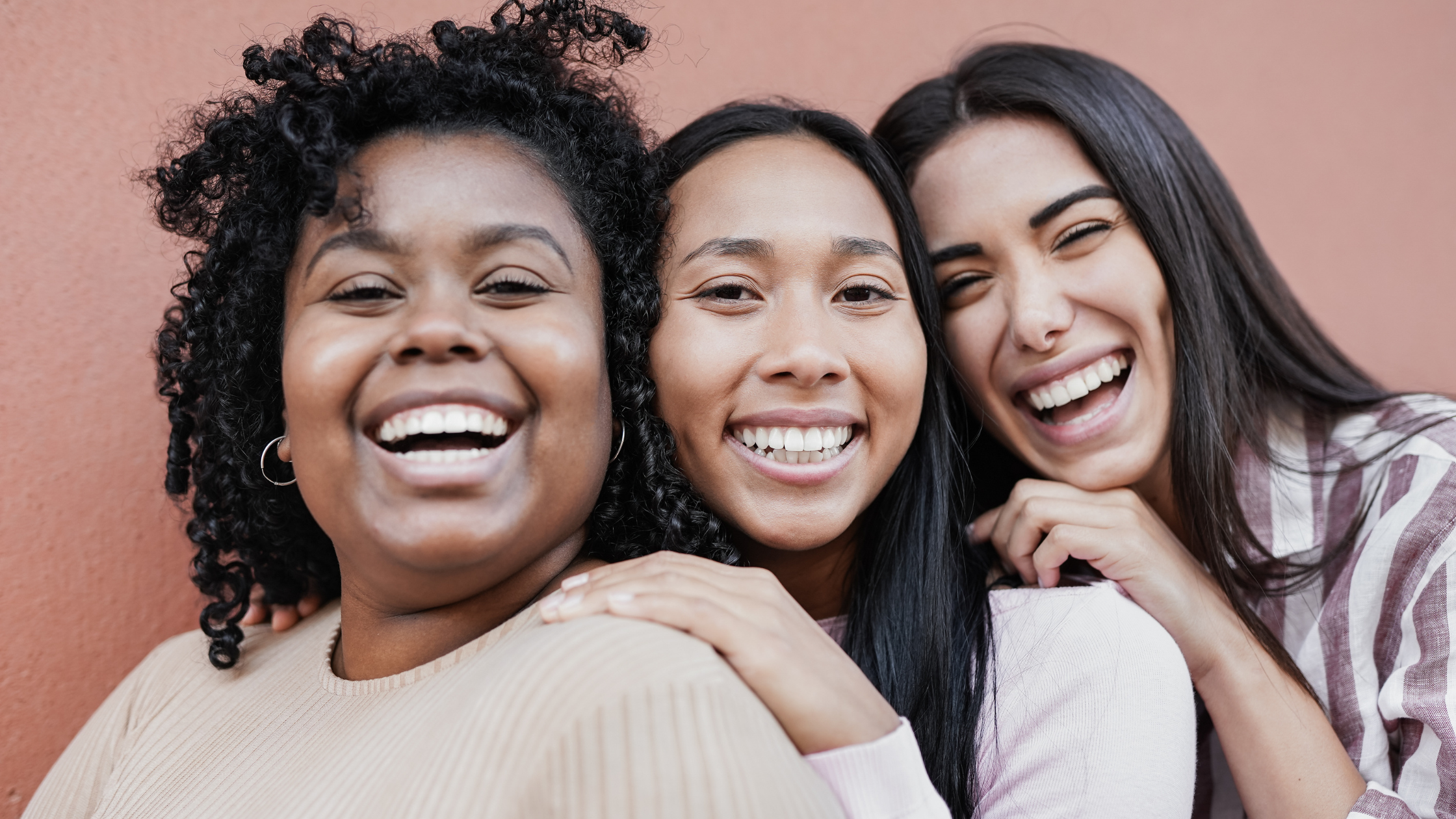 3 Women smiling together looking at camera